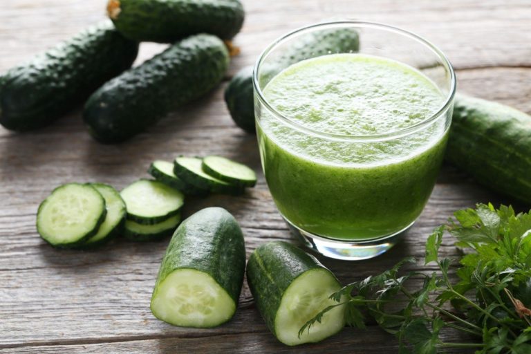 Cucumber Juice vs Celery Juice: Which is Better for Prediabetics? Glass of fresh cucumber juice with sliced cucumbers on a wooden table, highlighting its refreshing and hydrating properties for prediabetics.