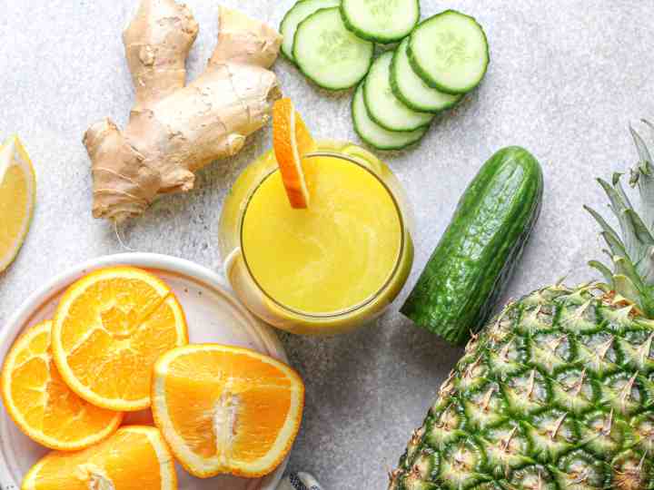 A glass of fresh Pineapple Cucumber Orange Juice on a kitchen counter, perfect for hydration, blood sugar balance, and energy boost before starting a workday.