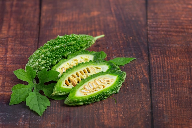 Can momordica charantia help manage type 2 diabetes: A fresh Momordica Charantia (bitter melon) cut in half to reveal its seeds, placed on a wooden cutting board, highlighting its potential role in managing type 2 diabetes.