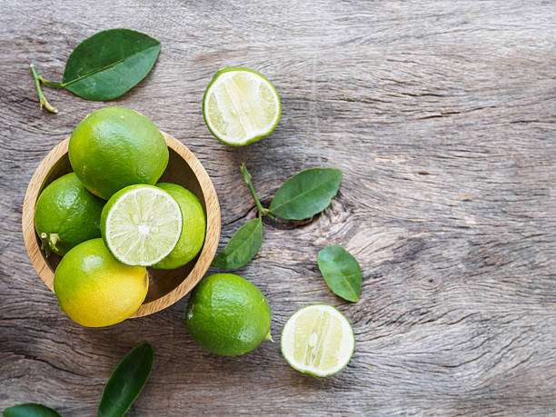 Is lime good for diabetes management? Lime is packed with vitamin C and fiber to help keep your blood sugar stabilized. Here's a fresh lime cut in half on a wooden surface, showcasing its juicy interior, symbolizing its health benefits for diabetes management.