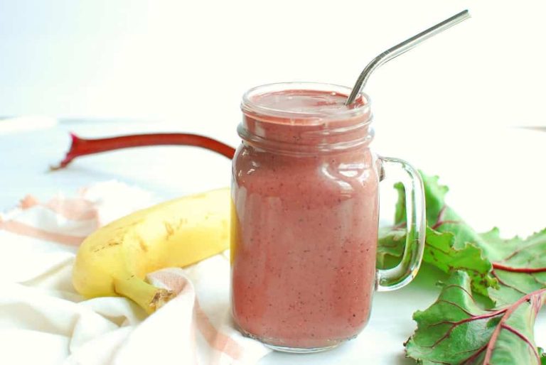 A vibrant beet spinach banana smoothie in a glass, surrounded by fresh beets, spinach leaves, and banana slices—perfect for replenishing iron and boosting energy after blood donation.