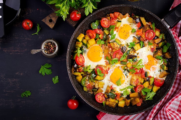 Are fried eggs healthy for people with hypertension: Fried eggs on a plate served with vegetables, a heart-healthy breakfast option for people with hypertension.