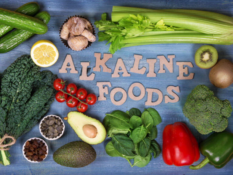 Alkalizing Foods to Manage Hyperchloremia Acidosis: Healthy alkaline foods like spinach, avocado, lemon water, carrots, and coconut water arranged on a wooden table — natural foods that help lower high chloride levels and manage hyperchloremia acidosis by balancing body pH and supporting kidney function.
