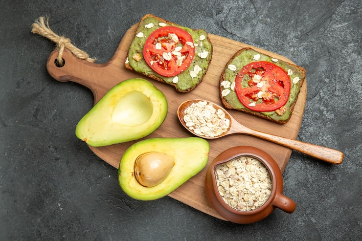 Best foods to clean arteries: Heart-healthy foods displayed on a table, including olive oil, avocados, oats, tomatoes, oranges, walnuts, blueberries, beans, sardines, and kale — natural foods that may help clean arteries and support cardiovascular health.