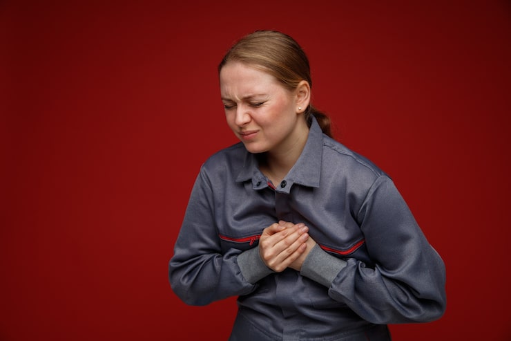 Woman clutching her chest in pain showing early signs of heart failure in women