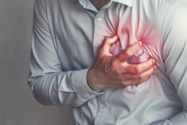 Man clutching his chest with red highlighted area showing early signs of coronary thrombosis and heart attack warning symptoms